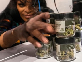 A worker organizes cannabis flowers before the opening of the first legal recreational marijuana dispensary located in Manhattan, N.Y., Thursday, Dec. 29, 2022.