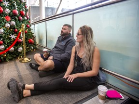 Trevor Anderson and Niya Guinn are headed Costa Rica, taking a rest at Terminal 1 departures level at Toronto Pearson International Airport on Friday, Dec. 23, 2022.