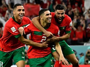Morocco's defender #02 Achraf Hakimi (C) celebrates with teammates after converting the last penalty during the penalty shoot-out to win the Qatar 2022 World Cup round of 16 football match between Morocco and Spain at the Education City Stadium in Al-Rayyan, west of Doha on December 6, 2022.