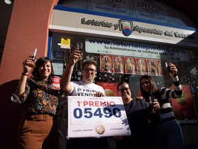 Lottery sellers of the "La Piedad" celebrate after selling a winning ticket of the first prize of Spain's Christmas lottery "El Gordo" (the Fat One) in Malaga, on Dec. 22, 2022.