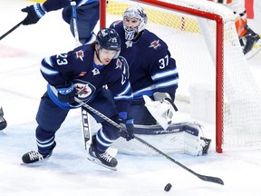 Winnipeg Jets center Michael Eyssimont (23) clears the puck in front of Winnipeg Jets goaltender Connor Hellebuyck (37) in the third period against the Anaheim Ducks at Canada Life Centre in Winnipeg on Sunday, Dec. 4, 2022.