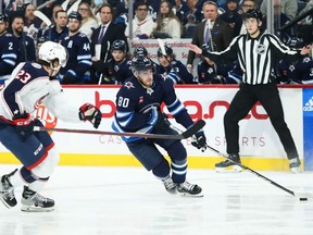 Winnipeg Jets forward Pierre-Luc Dubois (80) tries to skate around Columbus Blue Jackets defenseman Jake Christiansen (23 during the second period at Canada Life Centre in Winnipeg on Friday, Dec. 2, 2022.