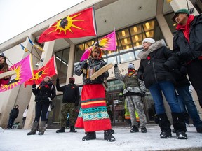 Sue Caribou, centre, sings a song in front of Winnipeg City Hall during a rally, Thursday, Dec. 15, 2022, to call on the city to cease dumping operations at a landfill and conduct a search for the remains of missing and murdered Indigenous women believed to be there.
