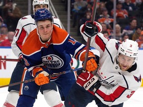Jesse Puljujarvi (13) of the Edmonton Oilers battles the Washington Capitals' Nick Jensen (3) during second period NHL action at Rogers Place in Edmonton on Dec. 5, 2022.