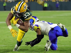 Aaron Jones of the Green Bay Packers avoids a tackle by Troy Hill of the Los Angeles Rams at Lambeau Field on December 19, 2022 in Green Bay, Wisconsin.