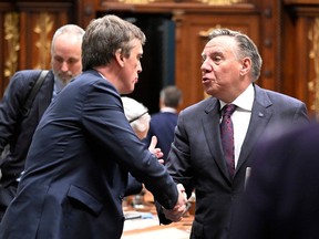 Premier François Legault, right, exchanges greetings with interim Quebec Liberal Party leader Marc Tanguay before the National Assembly wrapped up for the year on Friday.