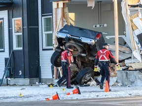Calgary police investigate at the scene where a truck drove into a house at the intersection of 76 Ave and 20a St. S.E. on Friday, January 6, 2023.
