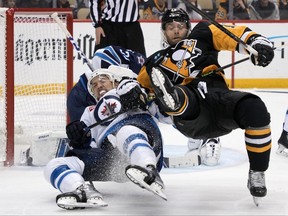 Pittsburgh Penguins' Bryan Rust, right, and Winnipeg Jets' Brenden Dillon collide during the second period in Pittsburgh on Friday night.