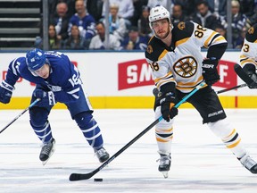 David Pastrnak of the Boston Bruins makes a pass ahead of Mitchell Marner of the Toronto Maple Leafs in Game Three of the Eastern Conference First Round during the 2019 NHL Stanley Cup Playoffs at Scotiabank Arena on April 15, 2019 in Toronto, Ontario, Canada.