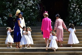 Britain's Catherine, Duchess of Cambridge (L) and Meghan Markle's friend, Canadian fashion stylist Jessica Mulroney (2L) holds bridesmaids hands as they arrive for the wedding ceremony of Britain's Prince Harry, Duke of Sussex and US actress Meghan Markle at St George's Chapel, Windsor Castle, in Windsor, on May 19, 2018. (Photo credit: BEN STANSALL/AFP via Getty Images)