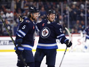 Nikolaj Ehlers (right) celebrates with teammate Brenden Dillon after scoring his first goal of the season in the second period for the Winnipeg Jets Sunday.