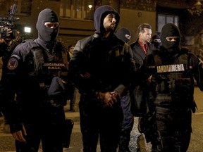 Andrew Tate and Tristan Tate are escorted by police officers outside the headquarters of the Directorate for Investigating Organized Crime and Terrorism in Bucharest (DIICOT) after being detained for 24 hours, in Bucharest,?Romania, Dec. 29, 2022.