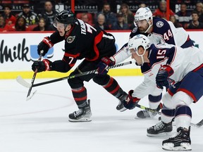 Ottawa Senators left wing Brady Tkachuk shoots as Columbus Blue Jackets defenceman Erik Gudbranson (44) and defenceman Gavin Bayreuther (15) defend during first period NHL action at the Canadian Tire Centre on Tuesday, Jan. 3, 2023.