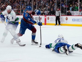 Defenceman Kyle Burroughs (right) sprawling out to block a shot in a game against the Colorado Avalanche earlier this season, leads the club in shot blocks per 60 minutes of even-strength ice time. The Canucks host the Avs on Thursday at Rogers Arena.