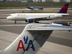 A Delta Air Lines plane taxis past an American Airlines plane at LaGuardia Airport in New York, on Monday, April 25, 2011.