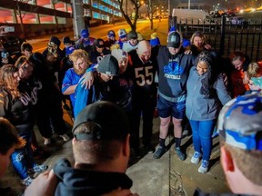 Football fans pray outside the University of Cincinnati Medical Center after Buffalo Bills defensive back Damar Hamlin collapsed on the field during the Monday Night Football NFL showdown with the Bengals in Cincinnati, Ohio, U.S., January 2, 2023.