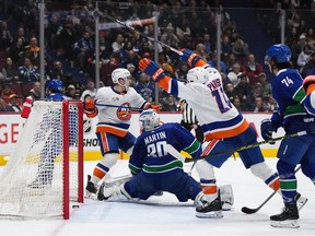 New York Islanders' Jean-Gabriel Pageau, back left, and Zach Parise (11) celebrate Pageau's goal against Vancouver Canucks goalie Spencer Martin (30) during the second period at Rogers Arena on Tuesday night.