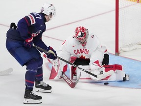 Canada goaltender Thomas Milic, right, makes a save on USA's Kenny Connors during the second period of IIHF World Junior Hockey Championship semifinal action in Halifax on Wednesday, Jan. 4, 2023.