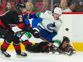 Vancouver Canucks defenceman Ethan Bear (74) checks Carolina Hurricanes centre Seth Jarvis (24) during the first period at PNC Arena.