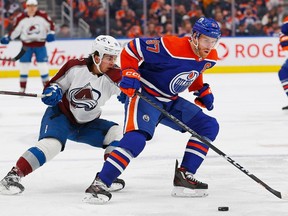 Edmonton Oilers forward Connor McDavid (97) protects the puck against Colorado Avalanche forward Alex Newhook (18) during the second period at Rogers Place.
