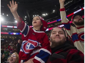 Nathan Choinière and his father, Jean-François, watch the Canadiens' skills competition at the Bell Centre in Montreal on Sunday, Feb. 19, 2023.
