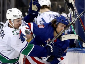 Luke Schenn of the Vancouver Canucks is checks Artemi Panarin of the New York Rangers in the face during the 2nd period of the game at Madison Square Garden on February 08, 2023 in New York City.
