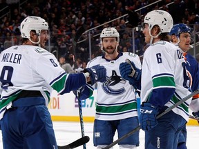 Brock Boeser of the Vancouver Canucks celebrates his first period goal against the New York Islanders and is joined by Conor Garland and Kyle Burroughs at UBS Arena Feb. 9, 2023.