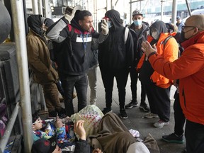 Recent immigrants to the United States talk to city officials in front of the Watson Hotel in New York, Monday, Jan. 30, 2023. The immigrants, mostly from Venezuela and other Latin American countries, had been living in the hotel until recently, when they were told to leave the temporary shelter.