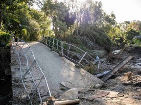 A general view of a damaged bridge after a small creek burst its bank causing houses to flood in Havelock North, New Zealand. Saturday, Feb. 18, 2023.