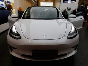 Visitors check a Tesla Model 3 car at a showroom of the U.S. electric vehicle maker in Beijing, China, Feb. 4, 2023.