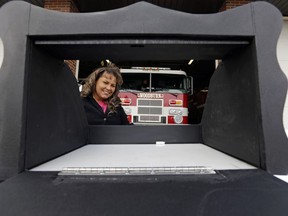 Monica Kelsey, firefighter and medic who is president of Safe Haven Baby Boxes Inc., poses with a prototype of a baby box, where parents could surrender their newborns anonymously, outside her fire station on Feb. 26, 2015, in Woodburn, Ind.