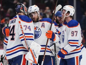 Edmonton Oilers goalie Stuart Skinner, left, Leon Draisaitl and Connor McDavid celebrate after Edmonton defeated the Vancouver Canucks 4-2 during an NHL game in Vancouver on Jan. 21, 2023.