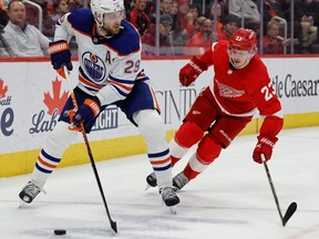 Edmonton Oilers center Leon Draisaitl (29) skates with the puck chased by Detroit Red Wings left wing Lucas Raymond (23) in the first period at Little Caesars Arena.