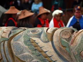 Family, friends and hereditary chiefs gather in a ceremony in Victoria on Monday, Feb. 13, 2023, to witness the historical repatriation of the Nuxalk Nation totem pole after years of effort to release the pole back to the nation from the Royal BC Museum.