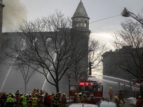 Montreal firefighters at scene of fire on du Port St. in Old Montreal on Thursday, March 16, 2023.