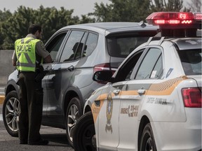 A Sûreté du Québec officer tickets a speeding driver.