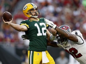 Aaron Rodgers of the Green Bay Packers throws a pass with pressure from William Gholston of the Tampa Bay Buccaneers during the fourth quarter in the game at Raymond James Stadium on September 25, 2022 in Tampa, Florida.