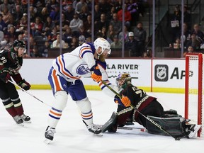 Mattias Ekholm of the Edmonton Oilers attempts a shot on goaltender Karel Vejmelka of the Arizona Coyotes during the second period of the NHL game at Mullett Arena on March 27, 2023 in Tempe, Arizona.