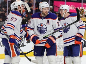 Connor McDavid #97, Leon Draisaitl #29 and Zach Hyman #18 of the Edmonton Oilers celebrate after McDavid assisted Draisaitl on a first-period power-play goal against the Vegas Golden Knights during their game at T-Mobile Arena on March 28, 2023 in Las Vegas. The Oilers defeated the Golden Knights 7-4.