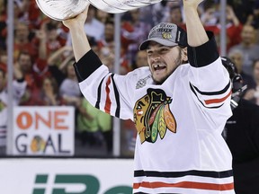 In this June 24, 2013, file photo, Chicago Blackhawks Daniel Carcillo hoists the Stanley Cup after the Blackhawks beat the Boston Bruins 3-2 in Game 6 of the NHL hockey Stanley Cup Finals in Boston.