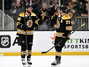 Boston Bruins right wing David Pastrnak, left, reacts with defenceman Charlie McAvoy after scoring a goal against the Columbus Blue Jackets during overtime at the TD Garden in Boston, March 30, 2023.
