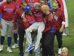 Edwin Diaz of Puerto Rico is helped off the field after being injured during the on-field celebration after defeating the Dominican Republic during the World Baseball Classic at LoanDepot park in Miami, Wednesday, March 15, 2023.