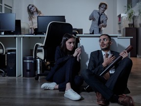 Two terrified office workers waiting for zombies on the floor in office.