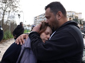 Panos Ruci hugs his wife Mirella after their son Denis was reported missing, following the collision of two trains near the city of Larissa, Greece, Friday, March 3, 2023.