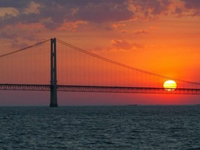 In this May 31, 2002 file photo, the sun sets over the Mackinac Bridge and the Mackinac Straits as seen from Lake Huron.