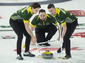 Team Northern Ontario skip Tanner Horgan, lead Colin Hodgson (right), and second Jacob Horgan deliver the stone against Nova Scotia during yesterday’s morning draw at the Brier. Curling Canada/Michael Burns Photo