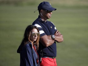 Tiger Woods, top, assistant U.S. team captain, and his girlfriend Erica Herman, watch play on the 17th hole during the final round of the Presidents Cup at Liberty National Golf Club in Jersey City, N.J., Oct. 1, 2017.
