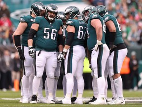 Isaac Seumalo #56, Jason Kelce (62) and Landon Dickerson (69) of the Philadelphia Eagles huddle with their teammates against the San Francisco 49ers during the first quarter in the NFC Championship Game at Lincoln Financial Field on Jan. 29, 2023 in Philadelphia, Pa.