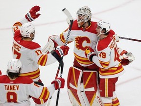 Calgary Flames goaltender Jacob Markstrom is surrounded by teammates in celebration after the team won 1-0 in a shootout against the Minnesota Wild Xcel Energy Center in St. Paul, Minn., on Tuesday, March 7, 2023.