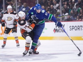 Anaheim Ducks' Troy Terry (19) is checked by Vancouver Canucks' Tyler Myers (57) during the first period of an NHL hockey game in Vancouver on Wednesday.